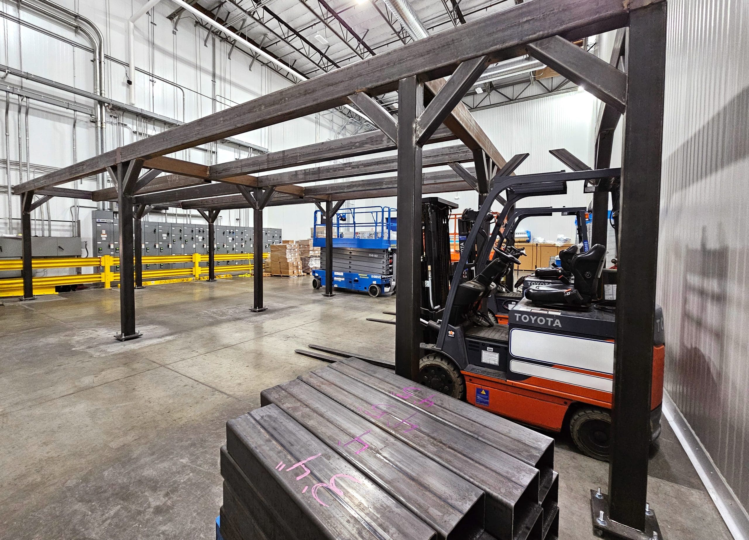 anchored carbon steel frame for structural mezzanine in food production facility