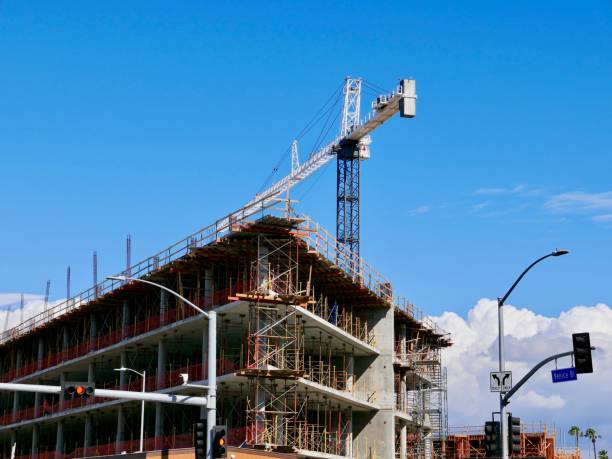 crane reaching across sky and new construction of buildings in los angeles, california